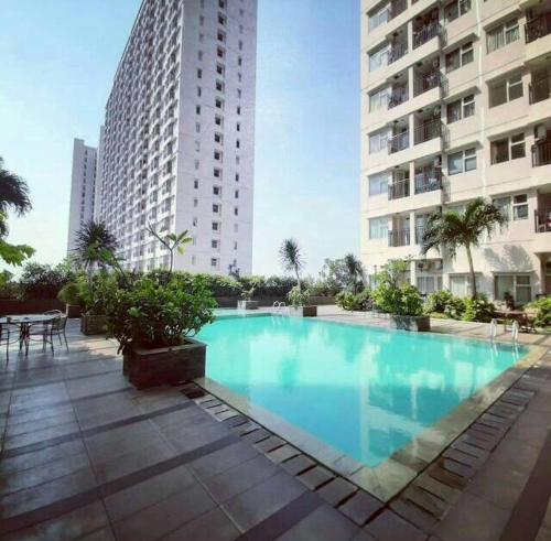 ein großer Pool vor einem hohen Gebäude in der Unterkunft Apartemen Margonda Residence 3 Depok in Kemirimuka Dua