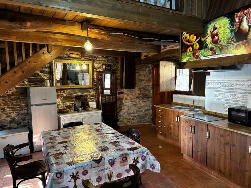 comedor con mesa y cocina en Casa Folibar - Desconexión en plena naturaleza - Valle del Silencio, en Manzanedo de Valdueza