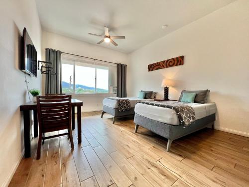 a bedroom with a bed and a couch and a table at Unit 7 Maui Ohana Modern Studio in Wailuku