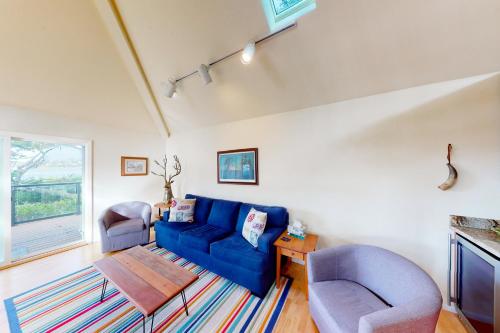 a living room with a blue couch and two chairs at Happy Clam Hideaway in Lincoln City