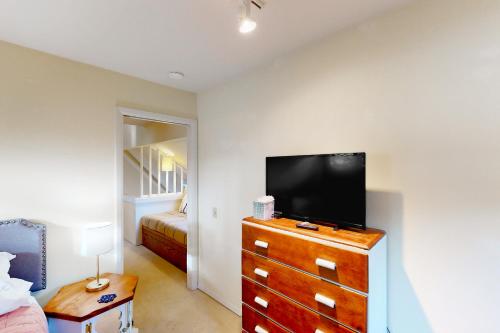 a living room with a tv and a dresser with a dresser at Happy Clam Hideaway in Lincoln City