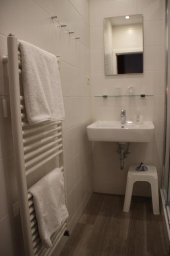 a white bathroom with a sink and a mirror at Haus Alexander in Heringsdorf