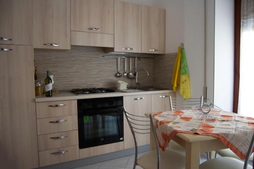 a kitchen with a table and a stove top oven at MADACHI APPARTAMENTI in Trapani
