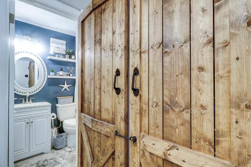 a bathroom with a wooden door and a toilet at Spa On Port Royal Sound 2217 in Hilton Head Island