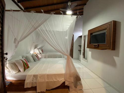 1 dormitorio con 1 cama con mosquitera en Hospedaria Zukka Trancoso, en Trancoso