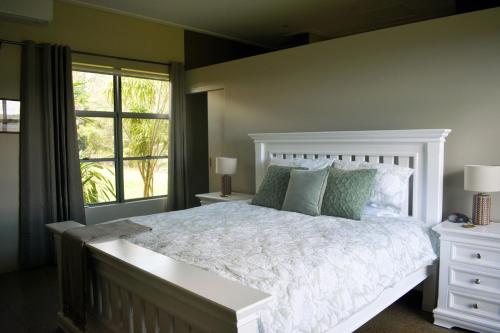 a bedroom with a white bed and a window at Arcadia Views in Witta