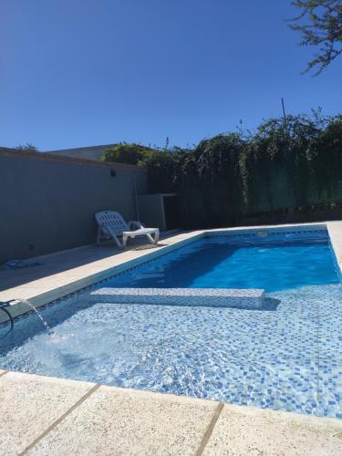 uma piscina com um banco ao lado de uma casa em Casa de montaña em San Roque