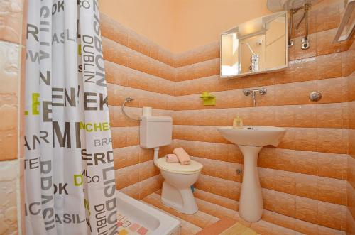 a bathroom with a toilet and a sink at Apartment and Room Ivica in Vodice