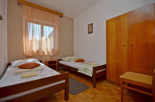una piccola camera con due letti e una finestra di Apartment and Room Ivica a Vodice