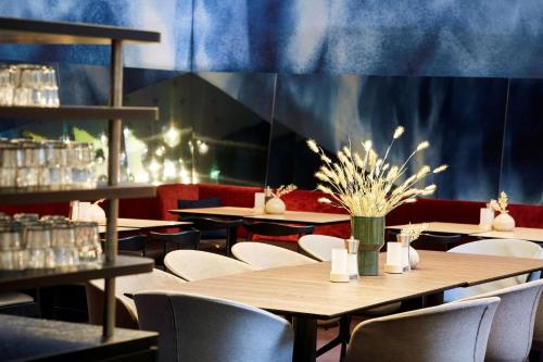 a restaurant with tables and chairs and a blue wall at Scandic Hamburg Emporio in Hamburg