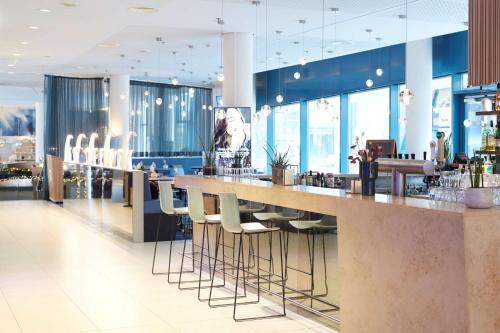 a bar in a restaurant with stools at Scandic Hamburg Emporio in Hamburg