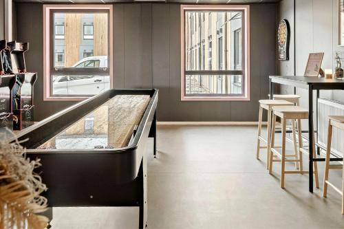 a restaurant with a counter and a bar with stools at Aiden by Best Western Herning in Herning