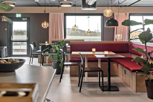 a restaurant with tables and chairs and potted plants at Aiden by Best Western Herning in Herning