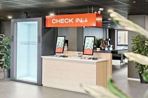 a check in counter in a building with a sign at Aiden by Best Western Herning in Herning