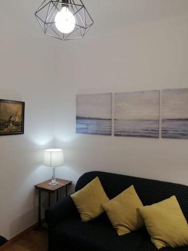 a living room with a black couch and a lamp at Casa da Praia da Poça - Apartamento Íris in Estoril