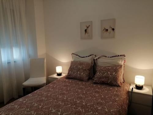 a bedroom with a bed with two lamps on it at Casa da Praia da Poça - Apartamento Íris in Estoril