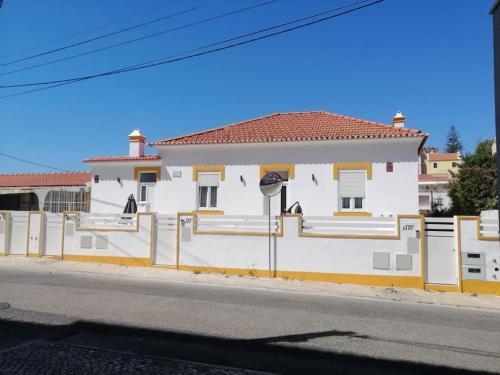 a white building with a fence next to a street at Casa da Praia da Poça - Apartamento Íris in Estoril