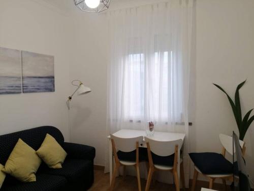 a living room with a table and a couch at Casa da Praia da Poça - Apartamento Íris in Estoril