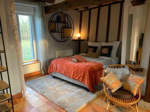 um quarto com uma cama, uma cadeira e uma janela em Git'Albert a 10 minute du château royale de Chambord em Mont-près-Chambord