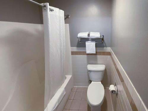 a small bathroom with a toilet and a bath tub at Motel 6 Norway MI in Norway