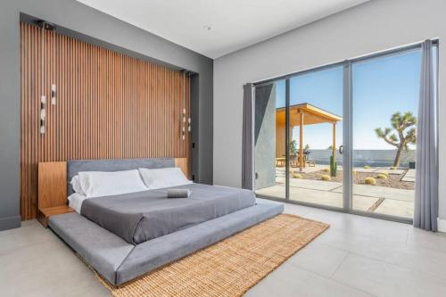 une chambre avec un grand lit et une grande fenêtre dans l'établissement Mountain View Paradise, à Yucca Valley