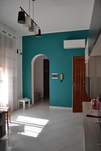 a kitchen with a blue wall and a hallway at MADACHI APPARTAMENTI in Trapani