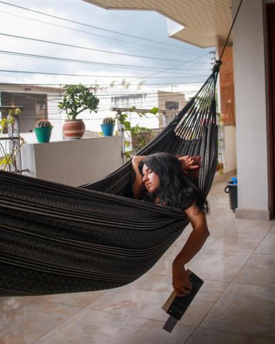 a woman laying in a hammock in a room at Casa Pacha in Guaduas