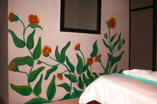 a bedroom with a flower mural on the wall at Casa Pacha in Guaduas