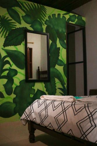 a bedroom with a green wall with a mirror at Casa Pacha in Guaduas