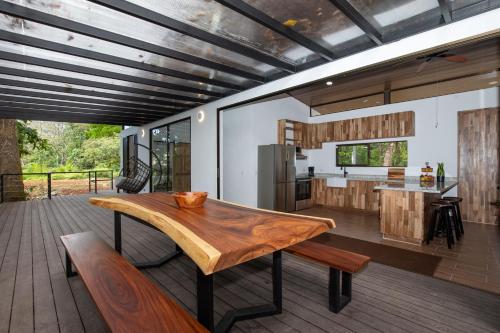 a kitchen and dining room with a wooden table on a deck at Casa Henaway - Portasol Vacation in Savegre