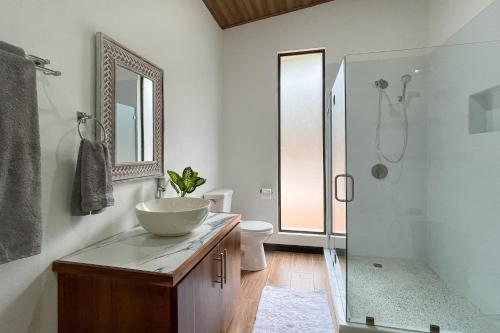 ein Bad mit einem Waschbecken und einer Glasdusche in der Unterkunft Casa Henaway - Portasol Vacation in Savegre