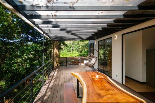 a wooden table on the deck of a house at Casa Henaway - Portasol Vacation in Savegre