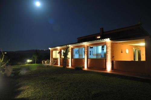 a house with lights on the side of it at night at Stazzo La Foci soluzioni vista Mare in Aglientu