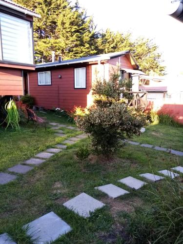 a garden with stepping stones in front of a house at Cabañas Rincón de Ten Ten in Castro