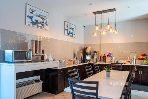 cocina con mesa y encimera con microondas en Ramada by Wyndham Redondo Beach, en Redondo Beach