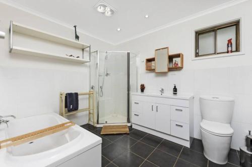 a bathroom with a shower and a toilet and a sink at Sweeping views of Hanging Rock and Cobaw Ranges in Mount Macedon