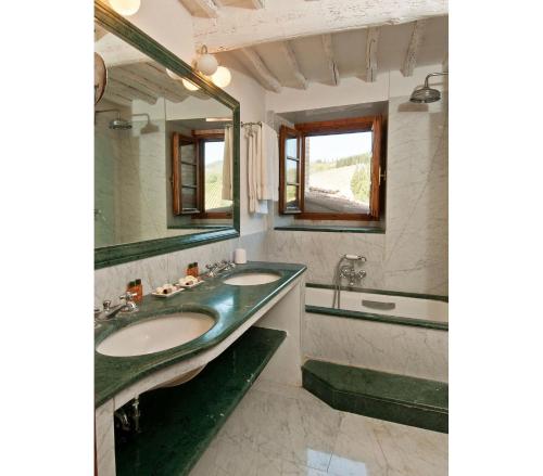 Un baño con dos lavabos, una bañera y un espejo. en Casavecchia 8 by Salogi Villas, en Volpaia