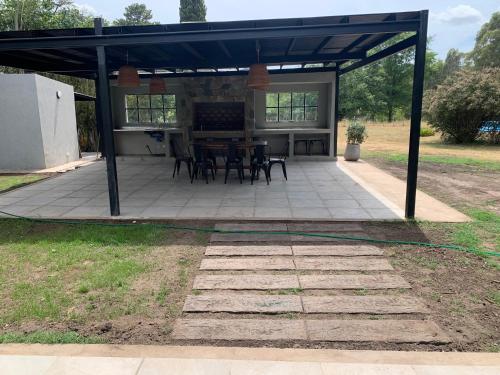 a patio with a table and chairs under a pavilion at Las Marias in Tandil
