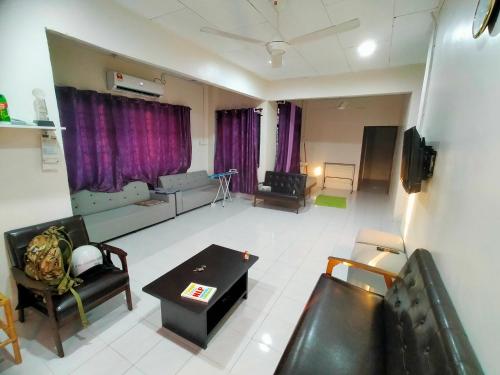 ein Wohnzimmer mit Sofas und einem Tisch im Zimmer in der Unterkunft Alor Setar Homestay in Kuala Kedah