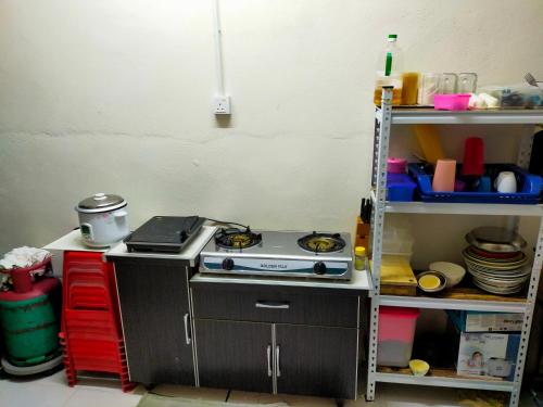 cocina con fogones y estante en Alor Setar Homestay en Kuala Kedah