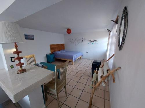 a living room with a table and a bedroom at Casa Nopal Tu casa vacacional tipo hotel in Creel
