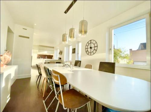 Charmante maison - centre-ville Colmar في كولمار: غرفة طعام مع طاولة بيضاء كبيرة وكراسي