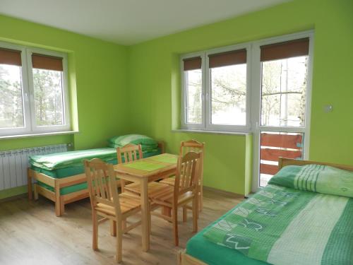 Cette chambre comprend une table, des chaises et un lit. dans l'établissement Pokoje Gościnne Przystań KAJA w Sobieskach nad Wkrą, à Sobieski