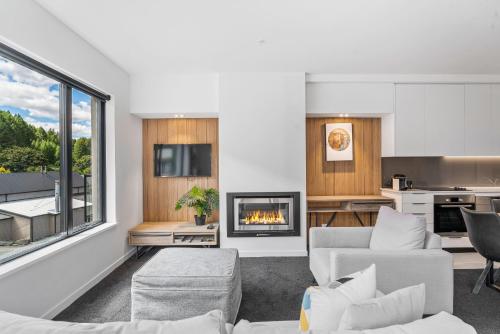 a living room with a couch and a fireplace at Residence du Parc Apartments By Staysouth in Queenstown