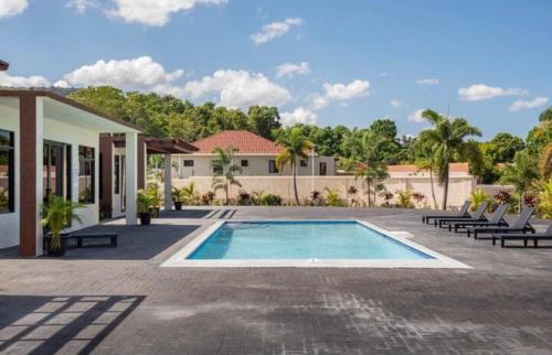 una piscina frente a una casa en Luxurious Villa Royale- 5 min drive to Ocho Rios, en Ocho Ríos