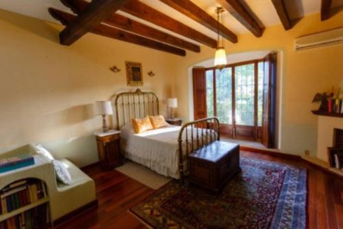 een slaapkamer met een bed en een groot raam bij Casa Laurel Oaxaca in Oaxaca City