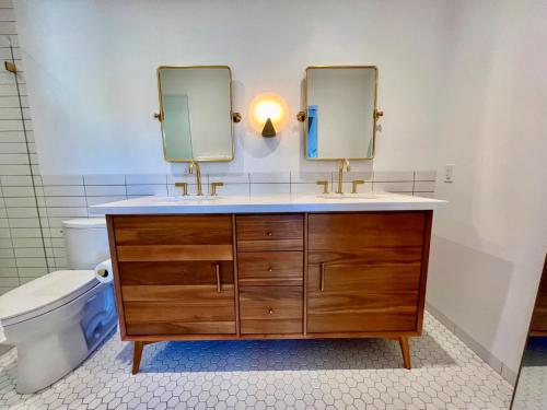 a bathroom with a vanity with two mirrors and a toilet at The Presidio in Santa Barbara