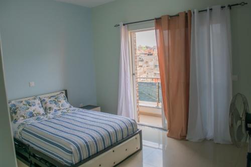 um quarto com uma cama em frente a uma janela em Comfortable and Cozy Apartments em Praia