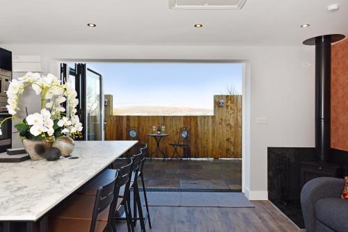 a kitchen with a counter with a vase of flowers at La Cantera in Merthyr Tydfil