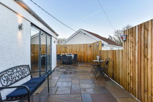 a patio with chairs and a wooden fence at La Cantera in Merthyr Tydfil